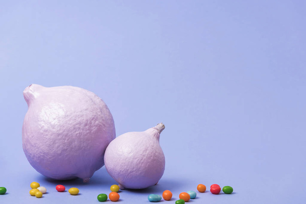 citrouilles peintes festives avec des bonbons sur fond violet
 - Photo, image