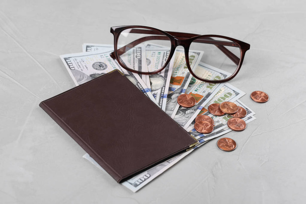 Pension certificate with American money and glasses on grey stone background - Foto, Bild
