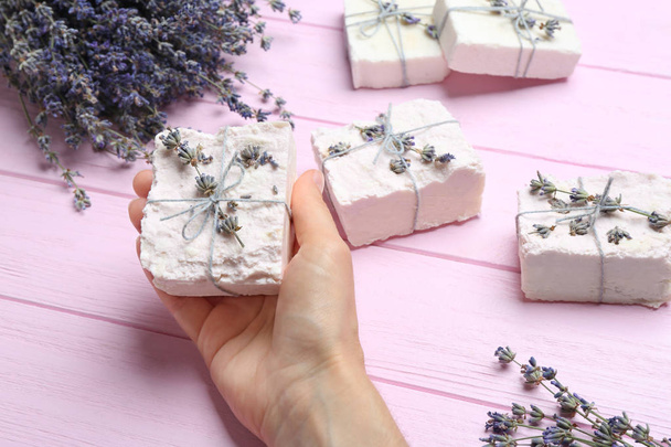 Woman holding hand made soap bar with lavender flowers on pink wooden background, closeup - Φωτογραφία, εικόνα