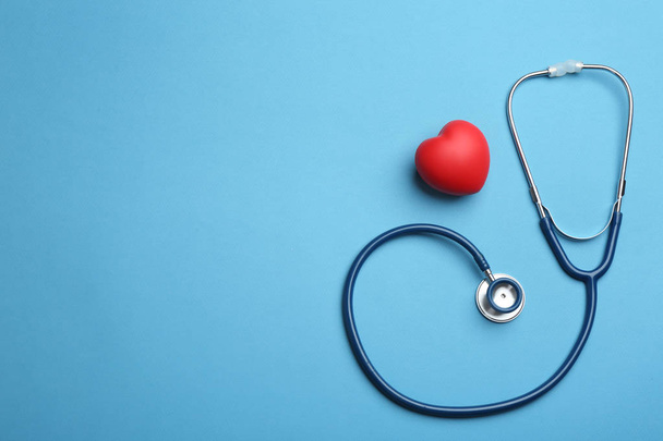 Stethoscope, red heart and space for text on blue background, flat lay. Health insurance concept - Foto, Bild