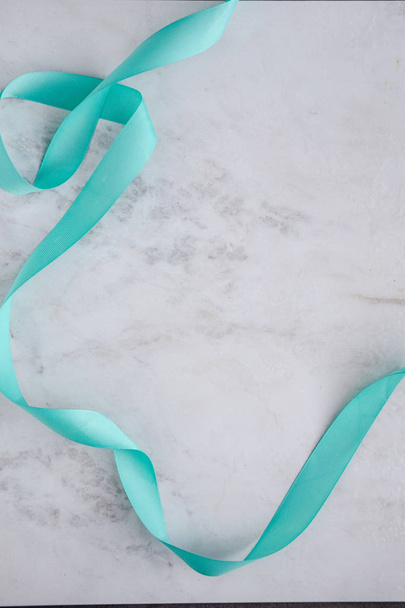 Blue curly ribbon on white marble table - Photo, Image