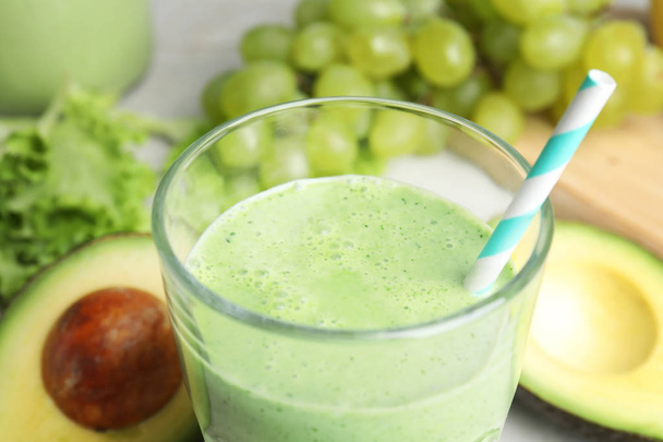 Glass of tasty avocado smoothie on table, closeup - Фото, изображение