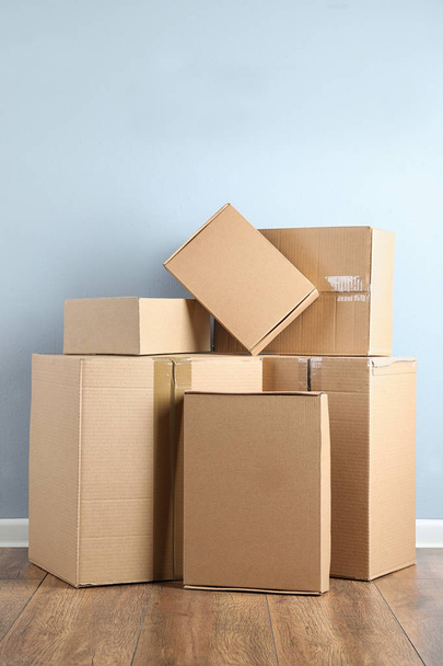 Pile of cardboard boxes near light blue wall indoors - Foto, Imagen