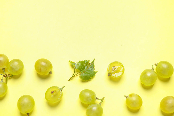 Flat lay composition with fresh ripe juicy grapes on yellow background, space for text - Foto, Bild