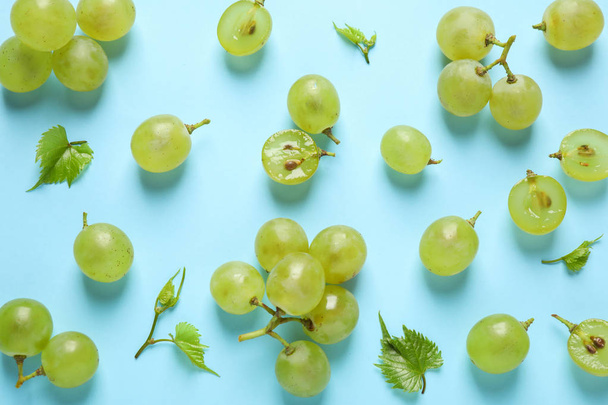 Flat lay composition with fresh ripe juicy grapes on light blue background - Фото, зображення
