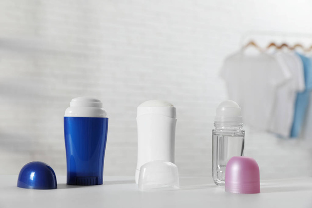 Different deodorants on white table in room - Фото, зображення