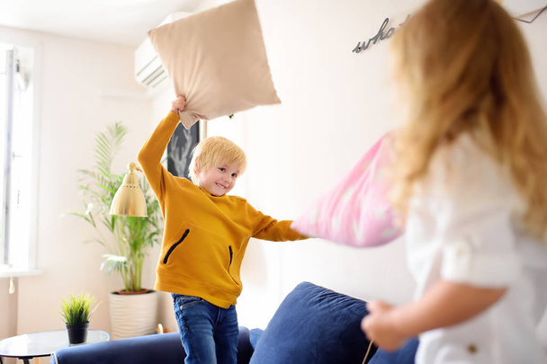 Pillow fight. Brother and sister play together. Active games for siblings at home. - Valokuva, kuva