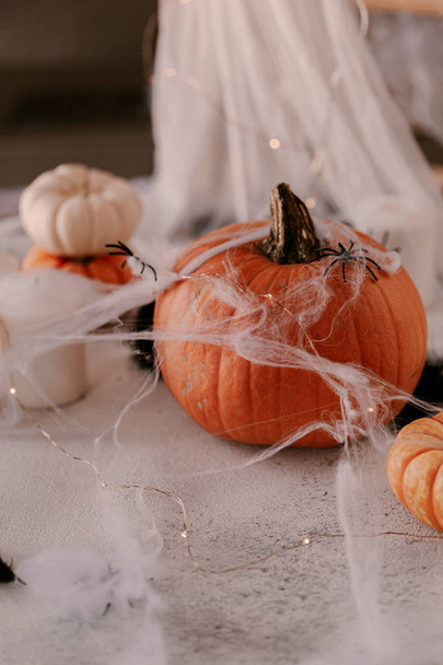 Decoração assustadora de Halloween com diferentes abóboras, luz, aranhas. Decoração de mesa Halloween
. - Foto, Imagem