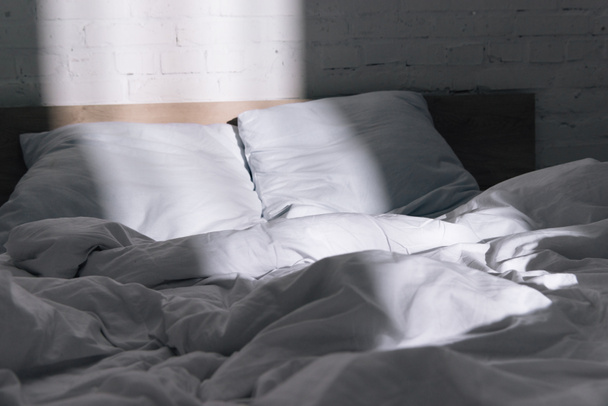 chambre à coucher avec lit, oreillers blancs et couverture en journée
 - Photo, image