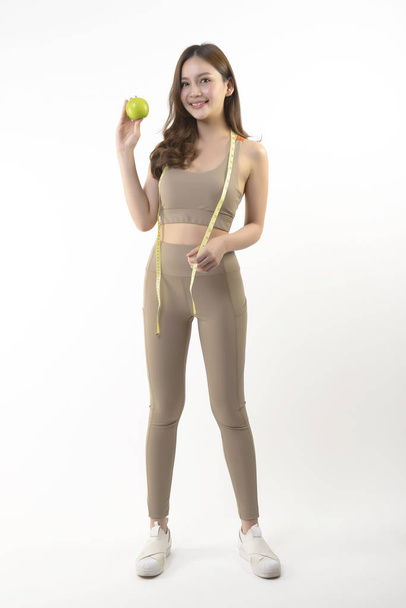 Pretty asian woman with apple and measure tape on white background. - Foto, Imagem
