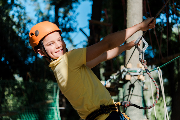 Lächelndes und nettes Kind mit orangefarbenem Helm draußen  - Foto, Bild