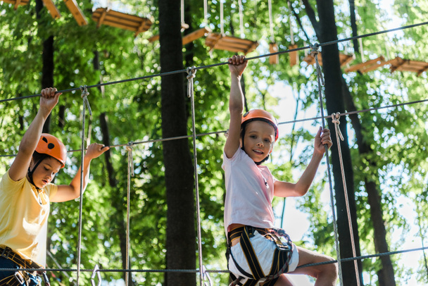 niños en cascos con equipo de altura en el parque de aventuras
  - Foto, Imagen