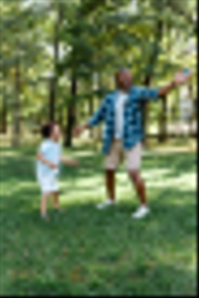 ευτυχισμένος Αφρικανός Αμερικανός πατέρας και γιός στέκεται στο γρασίδι στο πάρκο  - Φωτογραφία, εικόνα