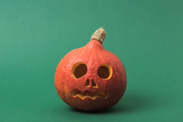 spooky Halloween pumpkin on green background - Photo, Image