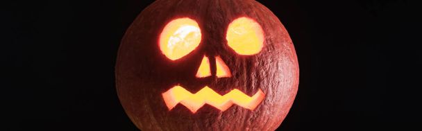 panoráma lövés kísérteties faragott Halloween-lámpa a sütőtök izolált fekete - Fotó, kép