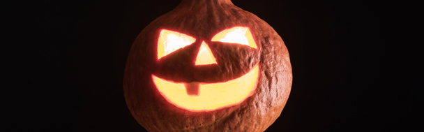 панорамный снимок пугающего резного Хэллоуинского фонаря из тыквы, изолированного на черном
 - Фото, изображение