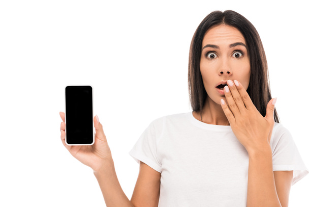 wstrząśnięta kobieta trzyma smartfon z pustym ekranem odizolowany na białym  - Zdjęcie, obraz