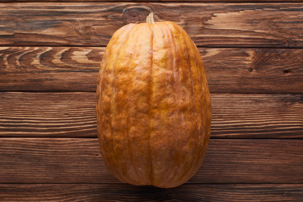 top view of long ripe pumpkin on brown wooden surface - Photo, Image