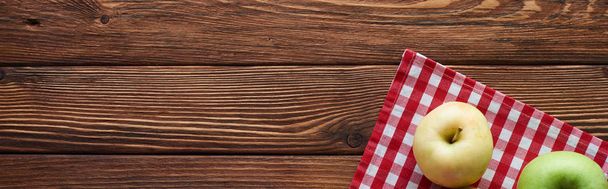 tiro panorâmico de toalha de mesa quadriculada com maçãs na superfície de madeira com espaço de cópia
 - Foto, Imagem