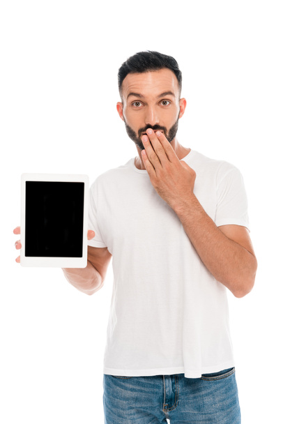 šokovaný muž zakrývající ústa a držící digitální tablet s prázdnou obrazovkou izolovanou na bílém  - Fotografie, Obrázek