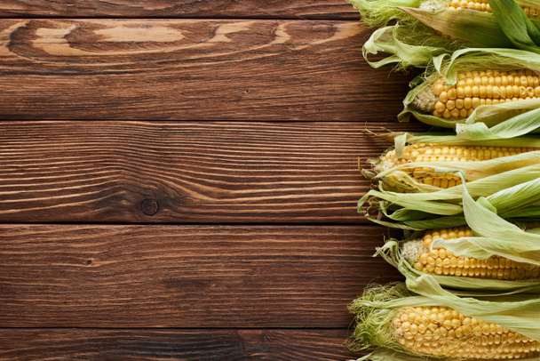 top view of raw corn on wooden surface with copy space - Foto, Imagem