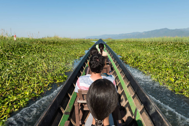 Οριζόντια εικόνα μιας ομάδας ξένων τουριστών κατά τη διάρκεια ενός ταξιδιού με σκάφος στη λίμνη Ίνλε, ορόσημο της Μιανμάρ - Φωτογραφία, εικόνα