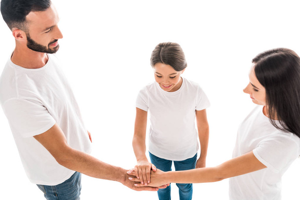 visão aérea da família sorridente colocando as mãos juntas isoladas no branco
  - Foto, Imagem