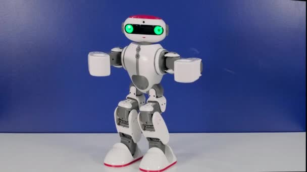 Маленькая забавная игрушка робота двигает руками, меняя позу
 - Кадры, видео