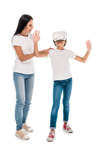 mother standing with kid in virtual reality headset isolated on white  - Valokuva, kuva