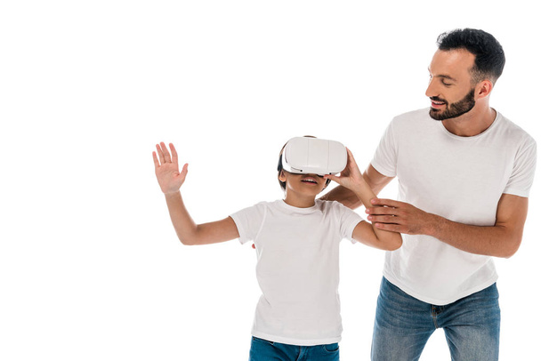 smiling father standing with happy kid in virtual reality headset isolated on white  - Foto, immagini
