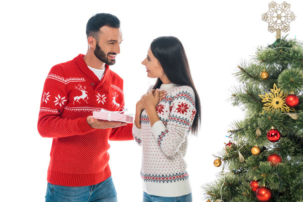 happy man holding gift near cheerful woman and christmas tree isolated on white  - Φωτογραφία, εικόνα