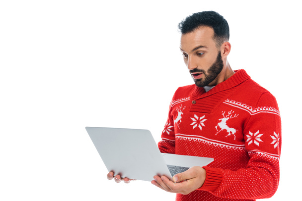 удивленный бородатый мужчина в свитере глядя на ноутбук изолирован на белом
  - Фото, изображение