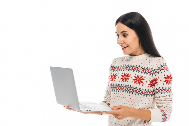 χαρούμενη γυναίκα σε πουλόβερ κοιτάζοντας φορητό υπολογιστή απομονωμένο σε λευκό - Φωτογραφία, εικόνα