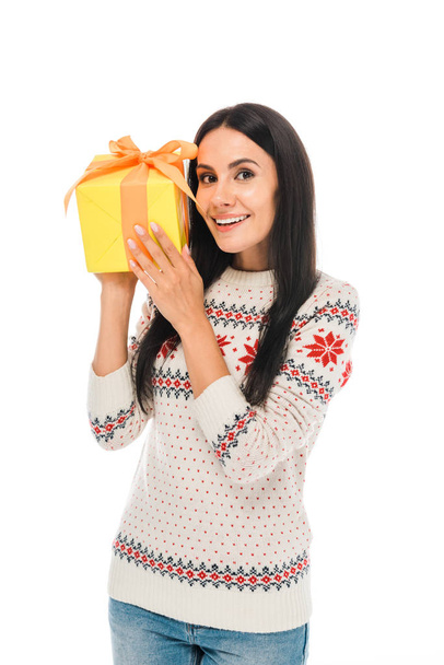 smiling woman in sweater holding gift isolated on white  - 写真・画像