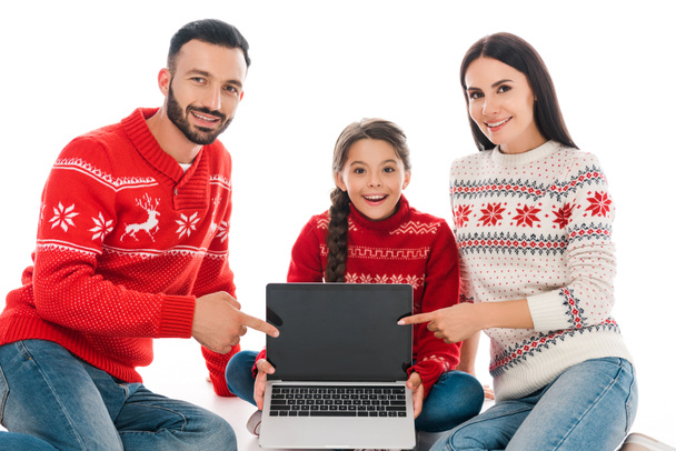 boldog szülők ujjal mutogatnak laptop üres képernyő közelében lánya elszigetelt fehér  - Fotó, kép
