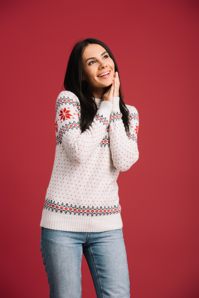 attractive happy girl posing in winter sweater isolated on red - Foto, imagen