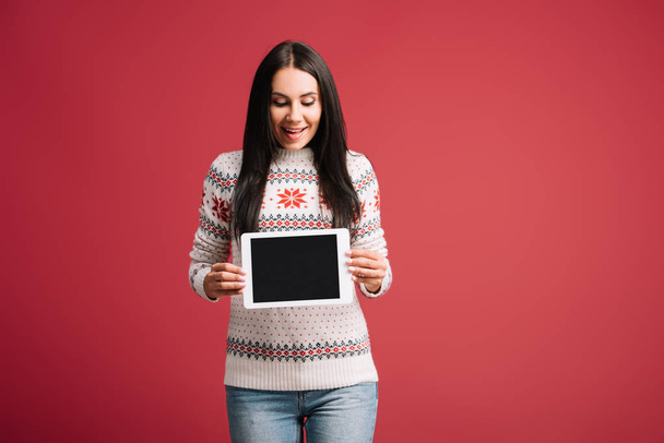 attractive smiling woman showing digital tablet with blank screen isolated on red - Фото, изображение