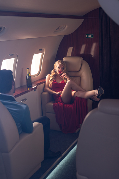 beautiful elegant sexy couple sitting in airplane  - 写真・画像