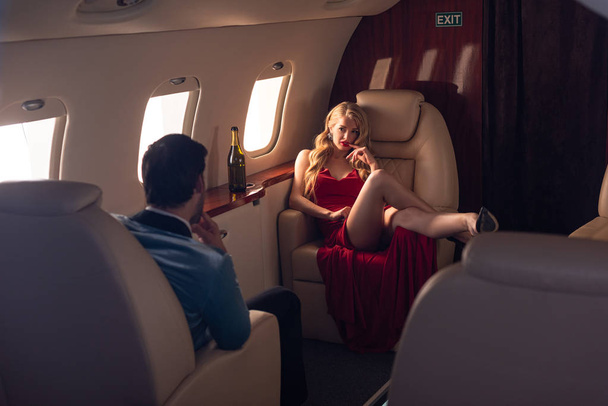 sexy girlfriend and boyfriend with champagne sitting in airplane - Foto, afbeelding