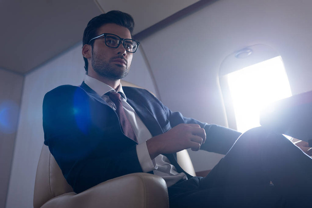 mężczyzna menedżer siedzi w samolocie podczas podróży służbowej  - Zdjęcie, obraz