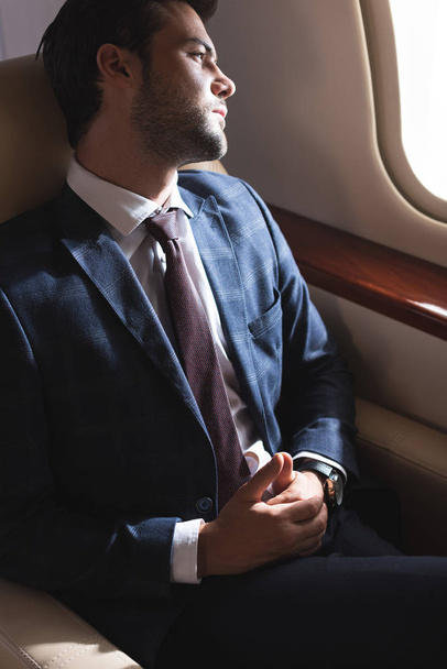 cher homme d'affaires regardant par la fenêtre dans l'avion
  - Photo, image