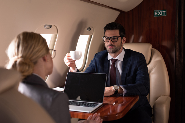 executive professional businesspeople having meeting with laptop in plane  - Φωτογραφία, εικόνα