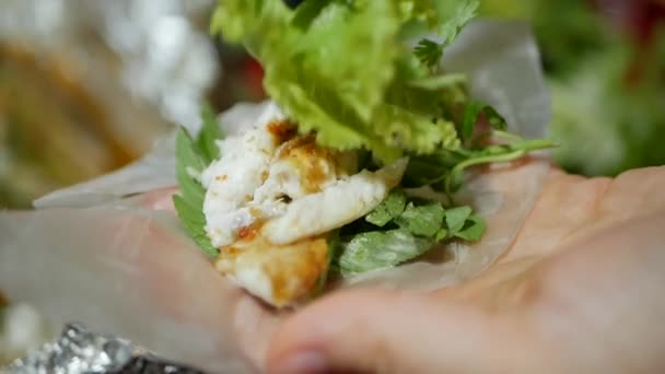 Tourists prepare and eat spring roll with rice paper wrapper or banh trang at night streetfood market. Traditional Vietnamese nem dish, asian cuisine. Close up - Footage, Video