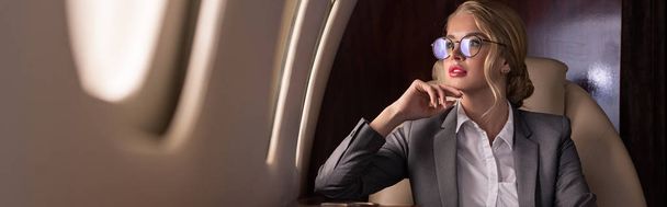 houkutteleva yritysjohtaja istuu lentokoneessa työmatkalla
 - Valokuva, kuva