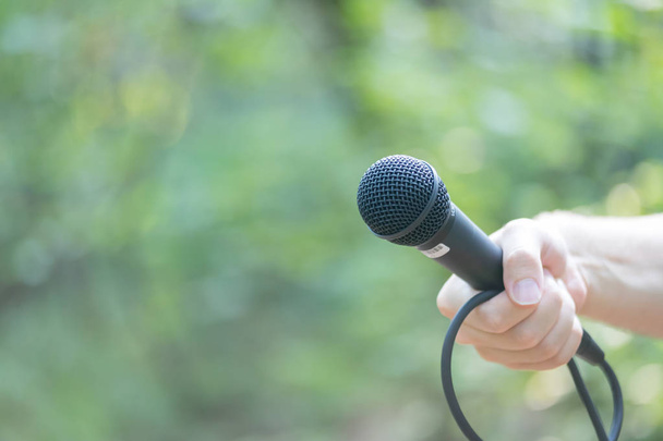 man with microphone in hand  on background,close up - Foto, Imagen