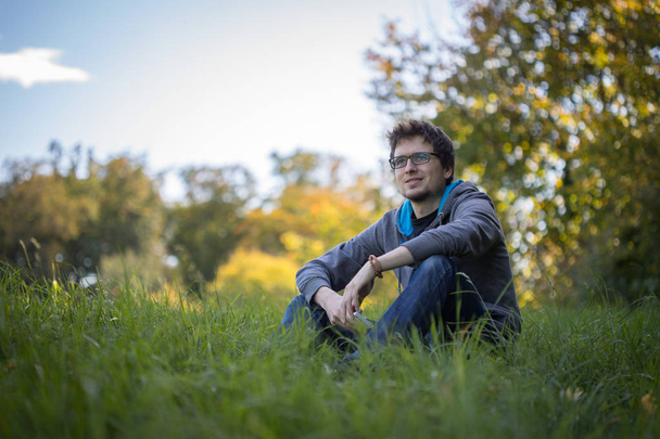 Homme relaxant sur l'herbe verte à l'extérieur
 - Photo, image
