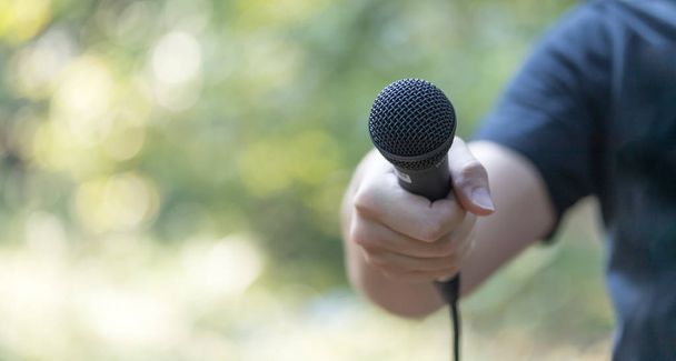 man with microphone in hand  on background,close up - Foto, Imagen