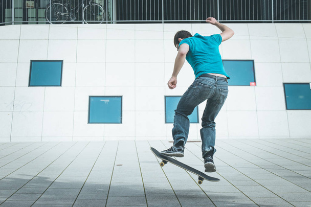 男性スケートボーダーがジャンプトリックを - 写真・画像