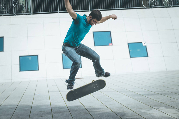 male skateboarder doing jump trick - 写真・画像