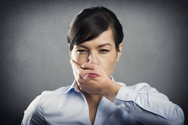Arrabbiata donna d'affari sconvolta con mano che si copre la bocca, isolata su sfondo grigio
. - Foto, immagini